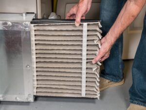 HVAC technician switching out air filter.