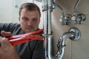 plumber-fixing-leaking-pipe-under-sink