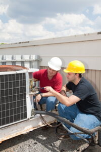 two-commercial-HVAC-technicians-working-on-a-rooftop-HVAC-unit